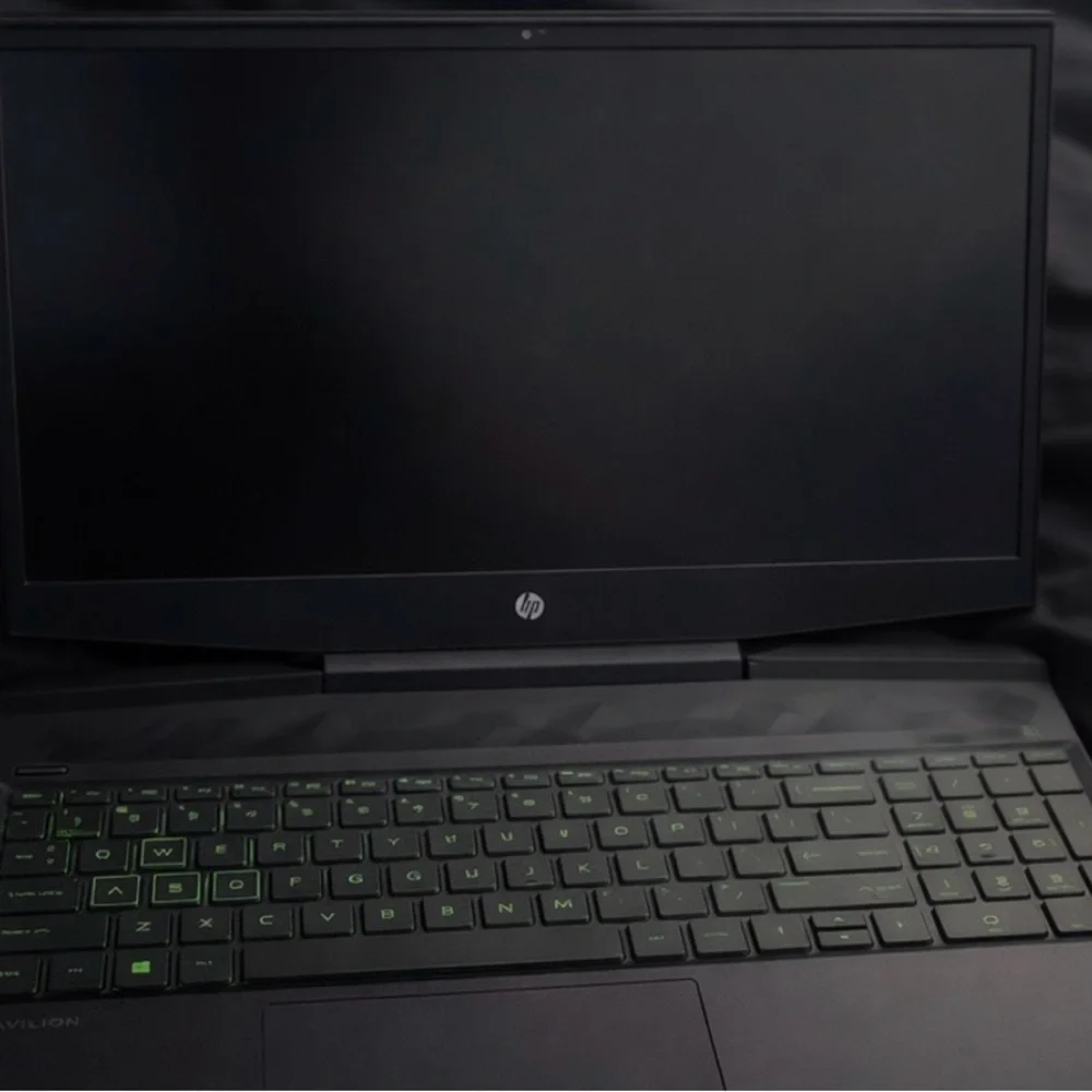 HP Laptop with Green Emblem on Black Surface